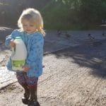 Family farm pictures of a young girl returning from the farm shop carrying milk.