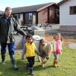 Family farm pictures of a young boy and girl walking Gypsy the Pony with Farmer Tony.