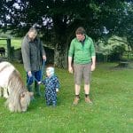 Family farm pictures of a young child with parents walking Gypsy the Pony at Lower Campscott.