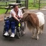Family farm pictures of a disabled guest walking Gypsy the Shetland Pony.