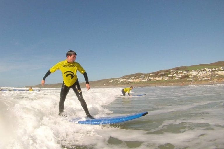 Man surfing at Woolacombe Beach near Lower Campscott Farm, as part of an active holiday in North Devon