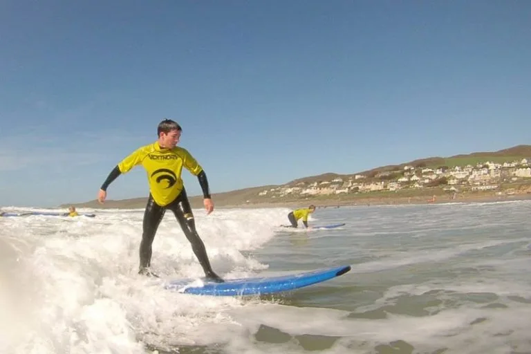 Man surfing at Woolacombe Beach near Lower Campscott Farm, as part of an active holiday in North Devon