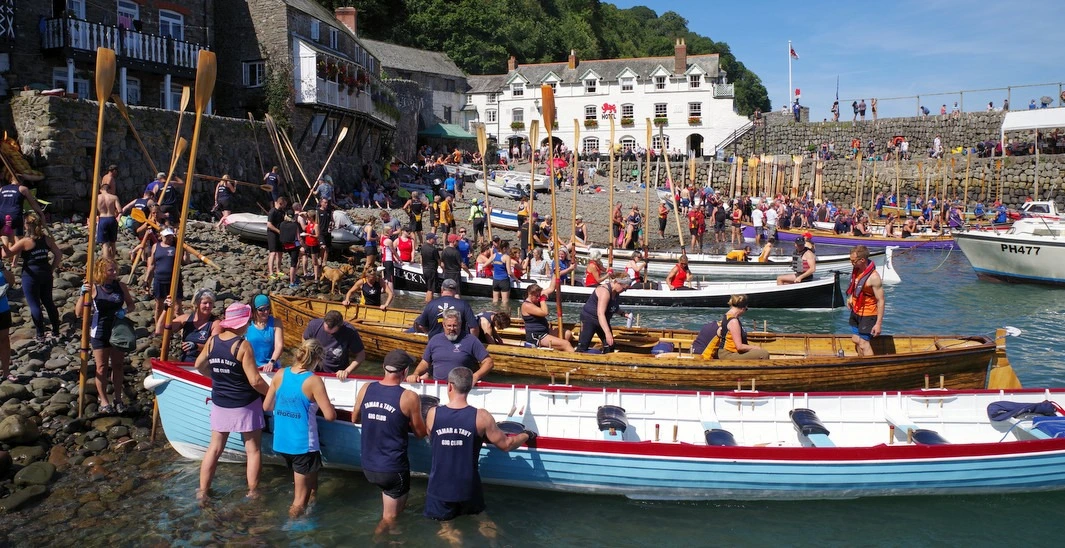 A crowd around a collection of pilot gigs on Clovelly harbour, close to Lower Campscott Farm.