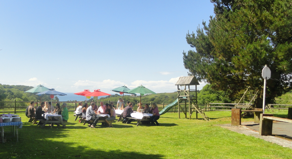 A family eating outdoors on the lawn at Lower Campscott Farm.